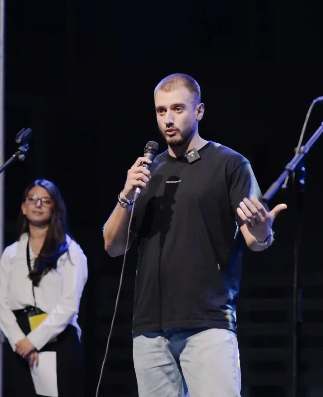 Will Dodevski speaking on stage at a conference
